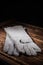 White leather welder gloves on a wooden background. A studio photo with hard lighting