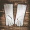 White leather welder gloves on a wooden background. A studio photo with hard lighting