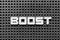 White letter in word boost on black pegboard background