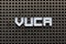 White letter in word VUCA abbreviation of Volatility, uncertainty, complexity and ambiguity on black pegboard background