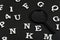 White letters and numbers and magnifying glass on black background. Search concept