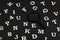 White letters and numbers and magnifying glass on black background. Search concept