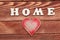 White letters with word HOME and heart on wooden background