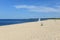 White lifeguard chair on empty sand beach with blue sky