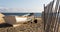 White lifeguards row boat on the sand next to a fence at Sunken Meadow State Park