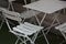 White light collapsible metal table and chairs in a summer outdoor cafe