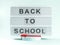 White lightbox with back to school text on light blue background with red pen on podium
