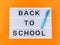 White lightbox with back to school text on yellow background with blue pen