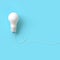 White lightbulb with wire on blue background for copyspace.