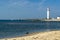 White lighthouse located on a seaside on sunny day. Symbol of in