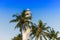 White lighthouse and palms tree with blue clean sky in Galle Fort, Sri Lanka.