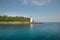 White lighthouse on rocky island lake side