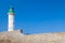 White lighthouse tower on stone pier