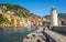 White lighthouse town pier - colored buildings - camogli on sunny day - italian riviera - liguria - Italy