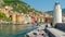 White lighthouse town pier - colored buildings - camogli on sunny day - italian riviera - liguria - Italy