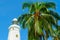 White lighthouse and tropical palms.