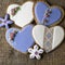 White and lilac heart-shaped cookies decorated with flowers and embroidery in vintage style on wooden background for Valentine`s