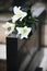 White lilies on black granite tombstone. Funeral ceremony