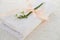 White linen napkin, finished with handmade lace, rolled in several layers, a delicate snowdrop flower is on a light table, the