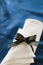 White linen silverware napkin with navy and gold striped holder on cobalt blue tablecloth