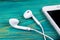 White little headphones and white smartphone on a blue rustic wooden table. woodgrain texture