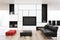 White living room with a black sofa, red