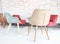 White living room with colorful red, grown, blue chairs, small table and white yellow red details pattern graphic decorations