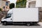 White lorry truck panel van parked in city with white empty mockup side for brand advertising