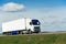 White lorry with white trailer over blue sky