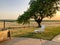 White lounge chair on a grassy knoll at sunset