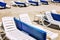 White loungers with blue mattresses on a public sandy beach