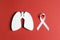 White lung cancer awareness ribbon and lung symbol on red background. November lung cancer awareness month