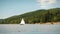 White luxury yacht sailing on lake surrounded by green trees. Harbor yacht club