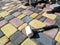 A white mallet, a building rope and a pile of bricks of sidewalk tiles against the background of newly laid paving slabs