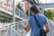 White man with blue t-shirt checks his smartphone while walking on a metallic urban walkway