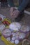 A white man lights a candle inserted into the Easter cake next to the red tomatoes and green cucumber.