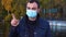 White man in medical protective mask disapproving with no finger sign make negation gesture.