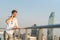 White man using mobile phone at rooftop during sunset, smiling while on phone call. Communication or telecommunication technology