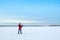 A white man in warm jacket works with a laptop on the frozen lake