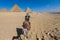 White Man and Woman Tourists are Riding on the Camels with the Great Pyramid on Background in Giza