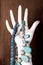 White mannequin hand holds necklaces jewley with blue and opal stones and white pearls