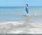 White marble table or floor, little shiny surface, perspective view, blurred cute Asian child girl running in seawater at beach ba