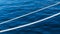 White marine mooring rope against background of blue water of Black Sea. Two white nautical cord. Background image