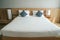 White mattress on minimal double bed with long big lamps at bedside in hotel bedroom