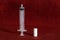 white medicine pills and a syringe lie on a burgundy background. health day. doctors and medicine. taking vitamins