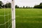 White metal soccer or football goal post and freshly cut training pitch. Cloudy sky. Simple sport background. Nobody. Cut green