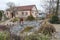 White middle-aged man cleans a garden pond with landing net from slime, water plants, falling leaves and catches fish