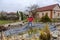 White middle-aged man cleans a garden pond with landing net from slime, water plants, falling leaves and catches fish