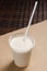 White milkshake with juice in a transparent glass. vertical view