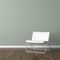 White modern chair on green wall